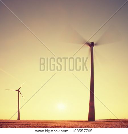 Modern Wind Turbines Producing Energy in sunny spring morning. Vintage Style Toned effect
