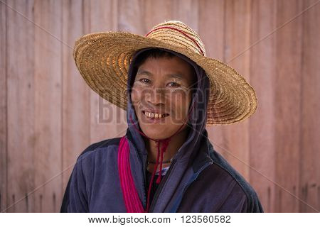 INLE LAKE MYANMAR - JANUARY 12 2016: Portrait burmese man a straw hat in local market. Inle lake Myanmar Burma