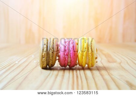 French Three color macarons on a woody floor at sunset