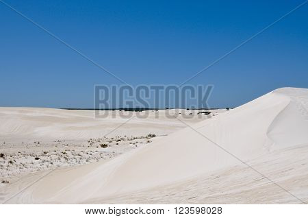 Stunning white desert landscape at the Lancelin Sand Dunes under a clear blue sky in Western Australia.