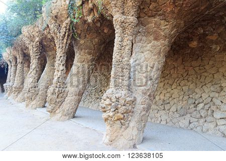 Barcelona, Spain - November 10, 2015: Colonnaded footpath in Park Guell. The Park Guell is a public park system composed of gardens and architectonic elements. The park was built between 1900 and 1914 and was designed by Antoni Gaudi.