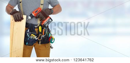 Builder handyman with drill and wooden plank.