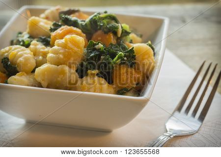 Vegetarian gnocchi dish with squash kale and mushrooms
