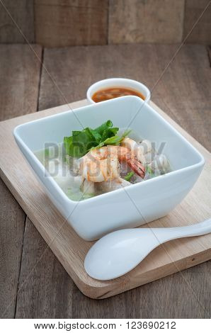 Thai food with Ekaehla and sauce on wood floor.