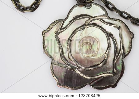 Close up of mother of pearl chain and pendant isolated on white background