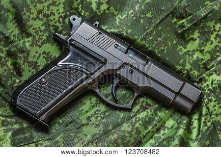 Weathered generic russian soviet semi-automatic 9mm pistol on pixel camouflage background