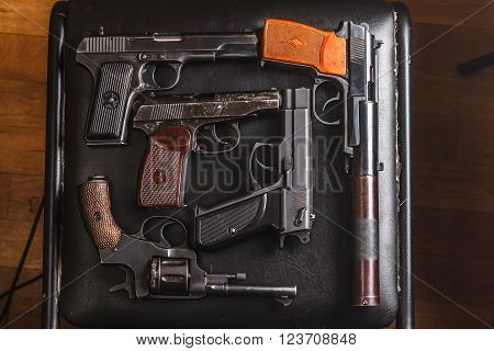 Weathered generic russian soviet semi-automatic 9mm pistols on black chair