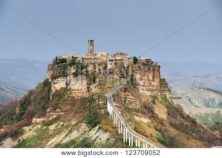 Civita di Bagnoregio, it is a small town in the Province of Viterbo in Italy. The town is famous for its position atop a plateau of friable volcanic tuff overlooking the Tiber river vally.
