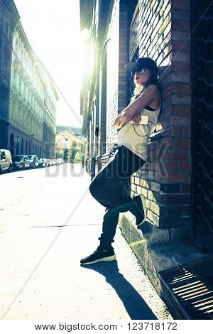 A beautiful young Hip Hop Rapper girl with Headphones in a urban environment.