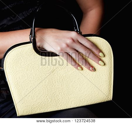 Close-up a pretty woman bag with matching nails