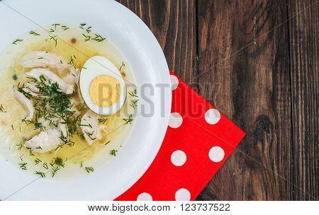 Chicken soup with noodles, carrots, eggs. closeup