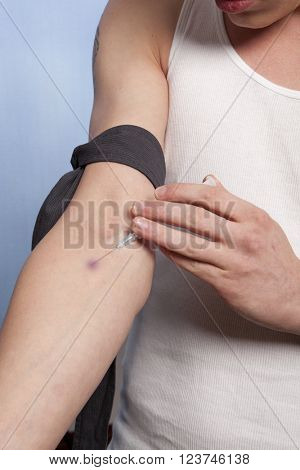 Drug addict man with syringe in action