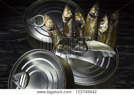 Close-up of Tinned capelin fish on dark wooden background
