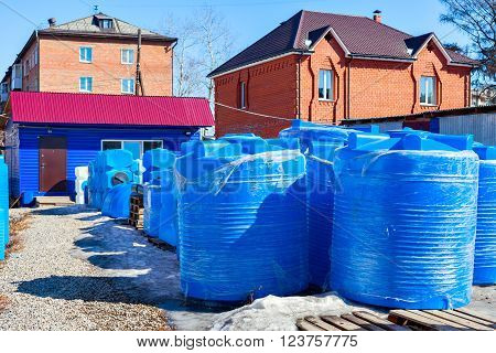 blue plastic water tank in the open air. Production of water tanks