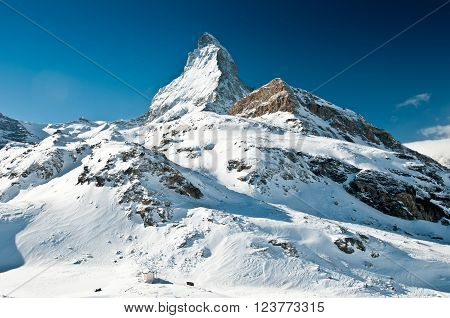 Scenic view on snowy Matterhorn peak in sunny day, Switzerland.