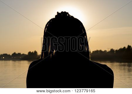 Male silhouette in the sunset. Warm summer evening.