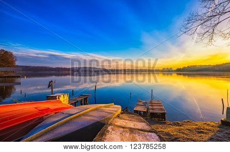 Sunrise over lake at end of winter. Frosty morning with sunrise over lake.