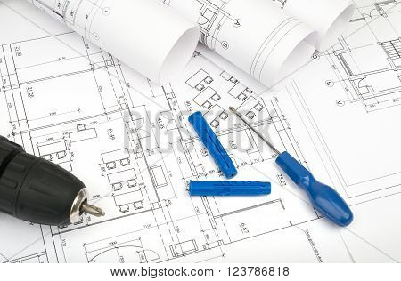 Architecture plan and rolls of blueprints with scredriver and electric screwdriver. Building concept