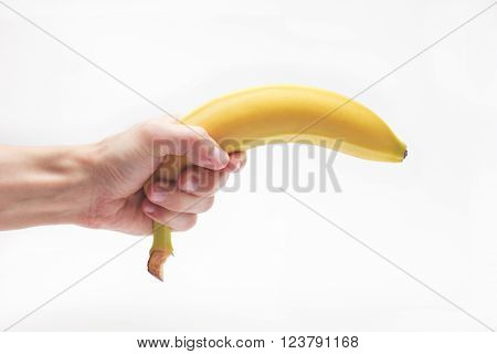 Banana fruit gun hold in caucasian white male hand over white background.