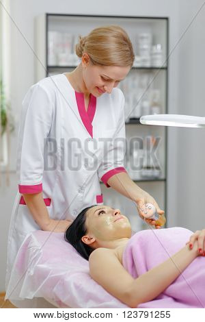 Face Skin Care. Young beautiful woman with dark hair gets procedure in the beauty salon.  Ultrasound Cavitation anti-aging, Rejuvenation, Lifting Procedure. Beauty Concept