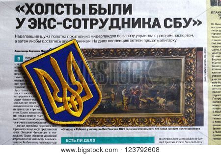 Kiev,Ukraine.FEB 20.ILLUSTRATIVE EDITORIAL.Chevron Ukrainian nazionalist battalion.Background - newspaper about West Frisian Museum stolen art . February 20,2016 in Kiev, Ukraine