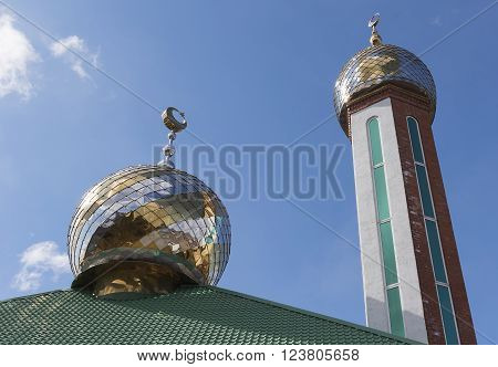 Two domes of the mosque against the blue sky with clouds