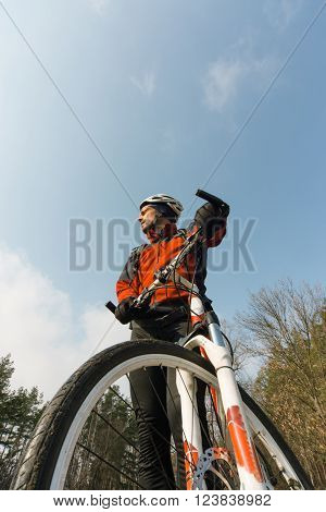 Male cyclist traveling through the woods in early spring.