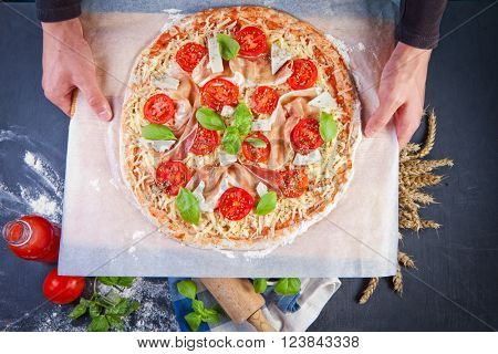 Closeup hand of baker making pizza at kitchen