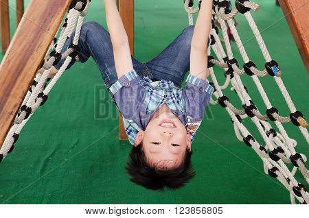 Young happy Asian boy playing in playground