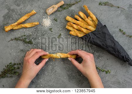 Fresh baked homemade breadsticks grissini with thyme and sea salt. Woman holding in hands grissini.
** Note: Soft Focus at 100%, best at smaller sizes