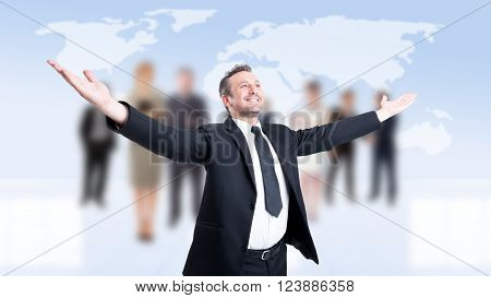 Successful business man with arms outstretched or outspread with business people background