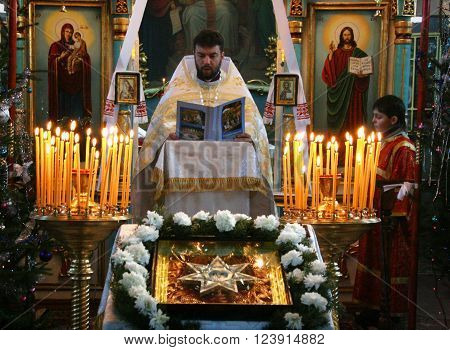 VOYUTYN UKRAINE - JANUARY 08: Orthodox priest and little sexton during Christmas service in Voyutyn on January 08 2009.