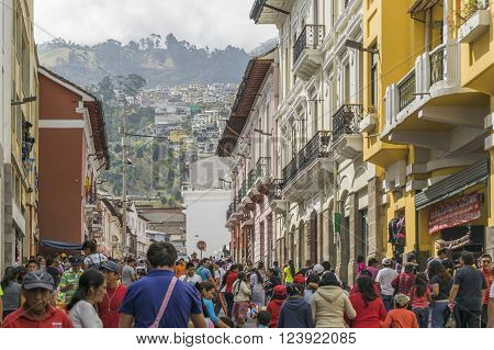 QUITO,  ECUADOR, OCTOBER - 2015 - Crowded sidewalk with colonial style buildings and hill at background in the historic center of Quito Ecuador.