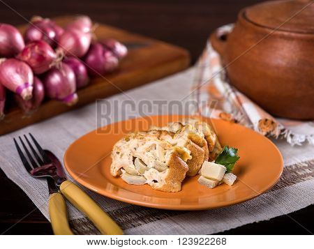 Artichoke bread pudding, budin de alcachofas, a typical Peruvian dish served on orange plate in rustic setting