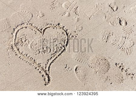 Heart in the sand, the symbol for love. Some foot prints
