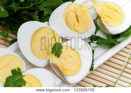 Sliced boiled eggs on long white plate. Close up.