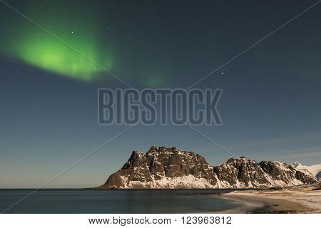 Northern lights over the sea at Utakleiv Beach Lofoten Islands Norway in the winter.
