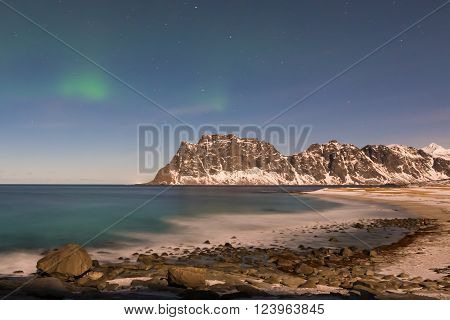 Northern lights over the sea at Utakleiv Beach Lofoten Islands Norway in the winter.