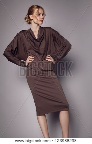 Beautiful Woman in stylish silk Dress posing in studio