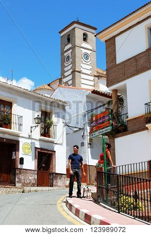 RIO GORDO, SPAIN - JUNE 1, 2008 - Couple with a dog standing on a street corner with the church to the rear Rio Gordo Malaga Province Andalusia Spain Western Europe, June 1, 2008.