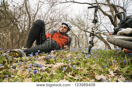 Male cyclist traveling through the woods in early spring.