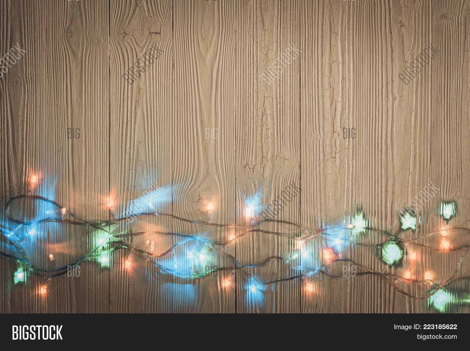 Fancy blinker light bulbs or garlands and wreath on wood table for Christmas or New years