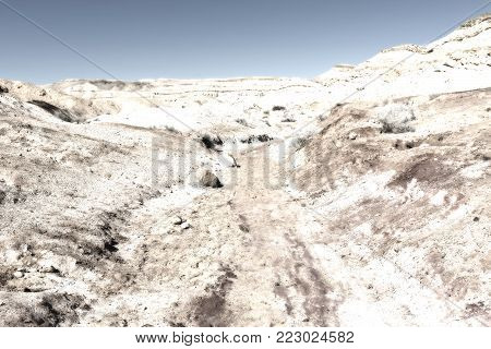 Rocky hills of the Negev Desert in Israel. Breathtaking landscape of the desert rock formations in the Southern Israel Desert. Dusty mountains interrupted by wadis  and deep craters.