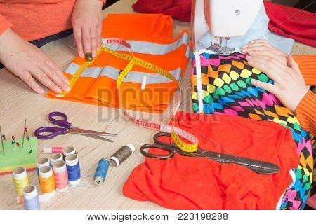 Tailor hands working with measure. Workplace of seamstress. Woman hand on sewing machine. people, needlework, sewing and tailoring concept