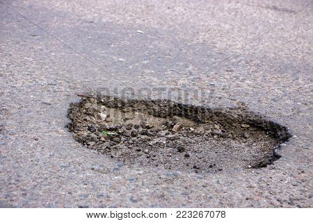 there are many potholes on the roadway close-up