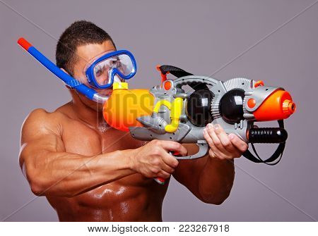 man playing with water guns in studio