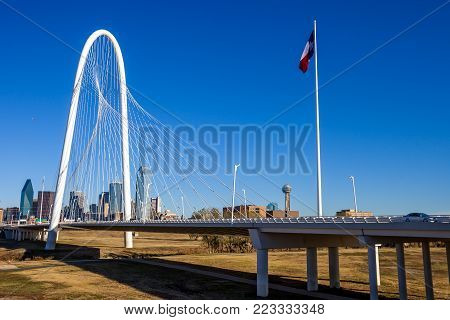 Margaret Hunt Hill Bridge with the Texas flag and Dallas skyline in the background