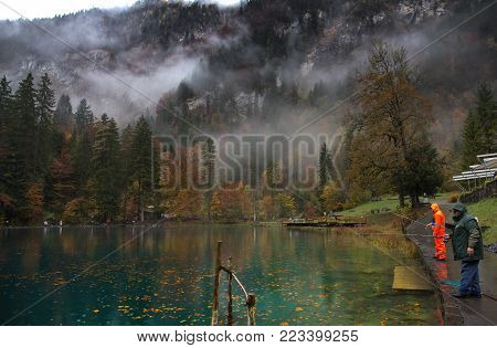 Tourists fishing for trout at Blausee lake, Switzerland
