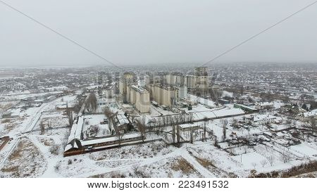 Grain Terminal In The Winter Season. Snow-covered Grain Elevator In Rural Areas. A Building For Dryi