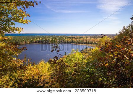 Scenic Autumn Lake Overlook. View from an overlook of a wilderness lake surrounded by lush autumn foliage in the Upper Peninsula town of Brimley, Michigan.